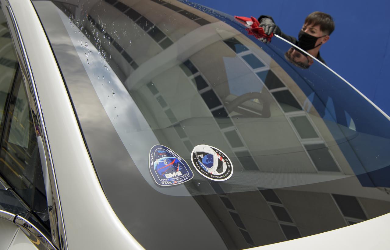 Stickers for the Demo-2 mission are seen on the front windshield of a vehicle in the convoy taking NASA astronauts Douglas Hurley and Robert Behnken from the Neil A. Armstrong Operations and Checkout Building for Launch Complex 39A to board the SpaceX Crew Dragon spacecraft for the Demo-2 mission launch, Wednesday, May 27, 2020, at NASA’s Kennedy Space Center in Florida. NASA’s SpaceX Demo-2 mission is the first launch with astronauts of the SpaceX Crew Dragon spacecraft and Falcon 9 rocket to the International Space Station as part of the agency’s Commercial Crew Program. The test flight serves as an end-to-end demonstration of SpaceX’s crew transportation system. Today’s launch of Behnken and Hurley was scrubbed due to weather and is now scheduled for 3:22 p.m. EDT on Saturday, May 30, from Launch Complex 39A at the Kennedy Space Center. A new era of human spaceflight is set to begin as American astronauts once again launch on an American rocket from American soil to low-Earth orbit for the first time since the conclusion of the Space Shuttle Program in 2011.  Photo Credit: (NASA/Bill Ingalls)