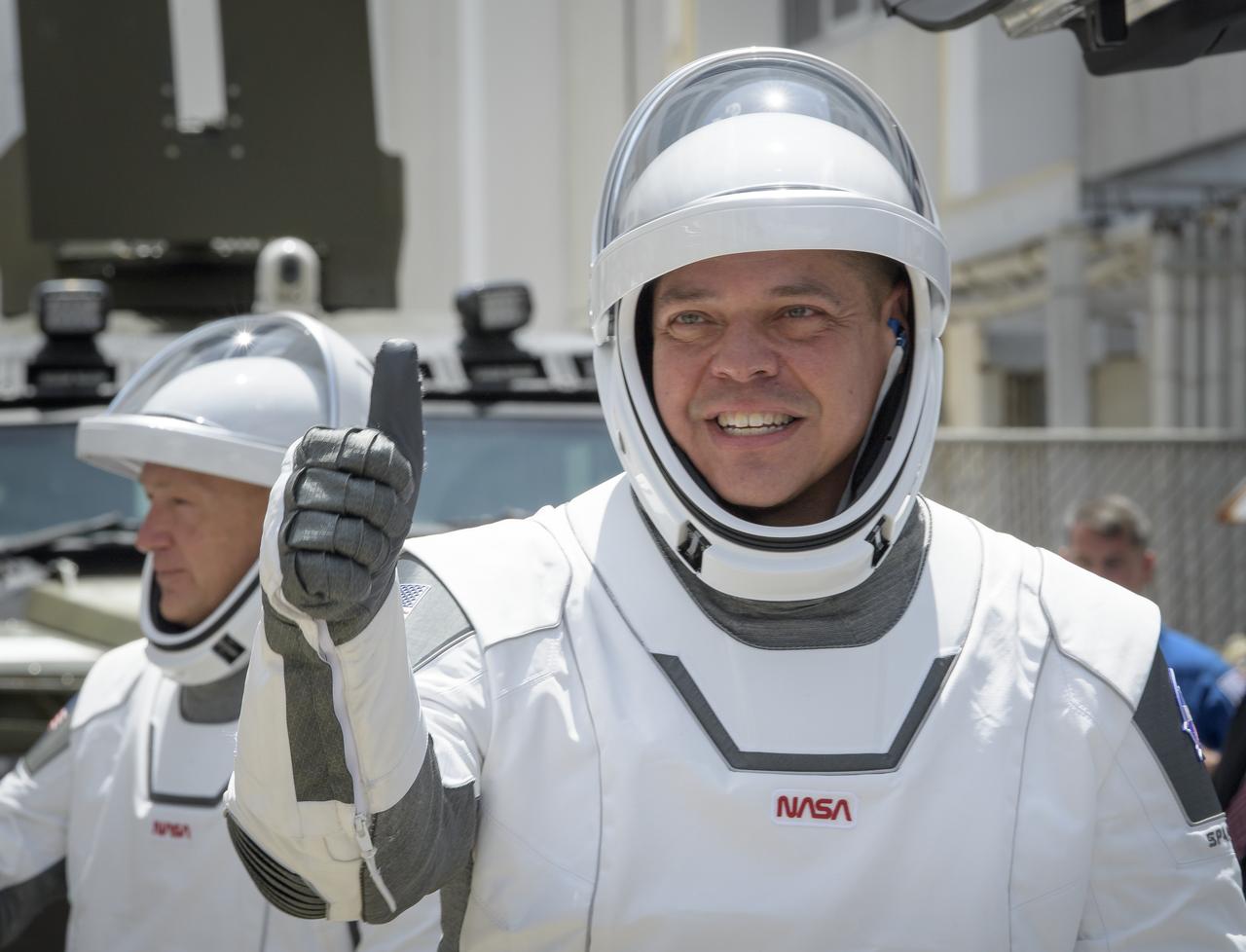 NASA astronauts Robert Behnken, foreground, and Douglas Hurley, wearing SpaceX spacesuits, are seen as they depart the Neil A. Armstrong Operations and Checkout Building for Launch Complex 39A to board the SpaceX Crew Dragon spacecraft for the Demo-2 mission launch, Saturday, May 30, 2020, at NASA’s Kennedy Space Center in Florida. NASA’s SpaceX Demo-2 mission is the first launch with astronauts of the SpaceX Crew Dragon spacecraft and Falcon 9 rocket to the International Space Station as part of the agency’s Commercial Crew Program. The test flight serves as an end-to-end demonstration of SpaceX’s crew ransportation system. Behnken and Hurley are scheduled to launch at 3:22 p.m. EDT on Saturday, May 30, from Launch Complex 39A at the Kennedy Space Center. A new era of human spaceflight is set to begin as American astronauts once again launch on an American rocket from American soil to low-Earth orbit for the first time since the conclusion of the Space Shuttle Program in 2011.  Photo Credit: (NASA/Bill Ingalls)