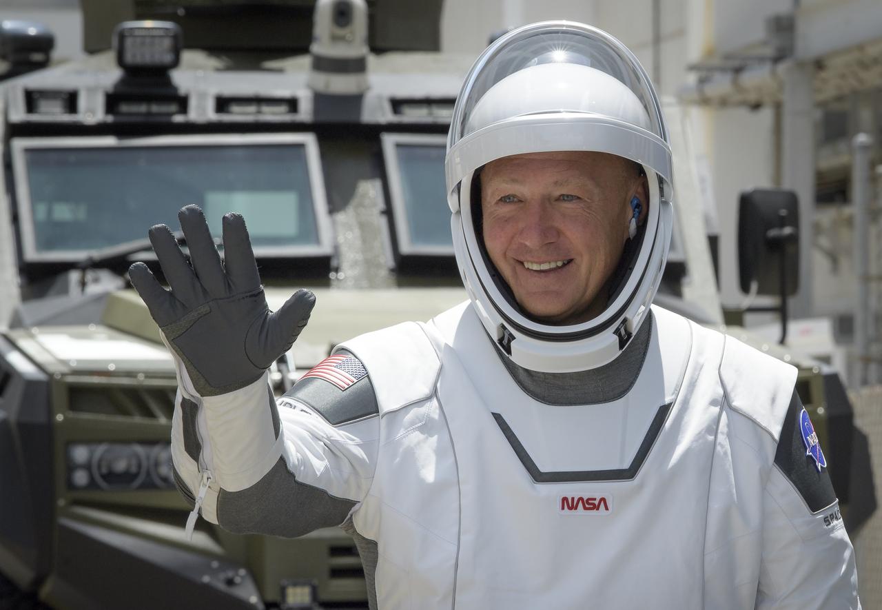 NASA astronaut Douglas Hurley waves as he and fellow crew member Robert Behnken depart the Neil A. Armstrong Operations and Checkout Building for Launch Complex 39A to board the SpaceX Crew Dragon spacecraft for the Demo-2 mission launch, Saturday, May 30, 2020, at NASA’s Kennedy Space Center in Florida. NASA’s SpaceX Demo-2 mission is the first launch with astronauts of the SpaceX Crew Dragon spacecraft and Falcon 9 rocket to the International Space Station as part of the agency’s Commercial Crew Program. The test flight serves as an end-to-end demonstration of SpaceX’s crew transportation system. Behnken and Hurley are scheduled to launch at 3:22 p.m. EDT on Saturday, May 30, from Launch Complex 39A at the Kennedy Space Center. A new era of human spaceflight is set to begin as American astronauts once again launch on an American rocket from American soil to low-Earth orbit for the first time since the conclusion of the Space Shuttle Program in 2011. Photo Credit: (NASA/Bill Ingalls)