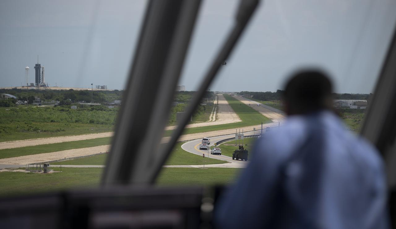 The convoy carrying NASA astronauts Robert Behnken and Douglas Hurley is seen through the windows of firing room four as it makes its way to Launch Complex 39A ahead of the launch of NASA’s SpaceX Demo-2 mission, Saturday, May 30, 2020, in the Launch Control Center at NASA’s Kennedy Space Center in Florida. NASA’s SpaceX Demo-2 mission is the first launch with astronauts of the SpaceX Crew Dragon spacecraft and Falcon 9 rocket to the International Space Station as part of the agency’s Commercial Crew Program. The test flight serves as an end-to-end demonstration of SpaceX’s crew transportation system. Behnken and Hurley are scheduled to launch at 3:22 p.m. EDT on Saturday, May 30, from Launch Complex 39A at the Kennedy Space Center. A new era of human spaceflight is set to begin as American astronauts once again launch on an American rocket from American soil to low-Earth orbit for the first time since the conclusion of the Space Shuttle Program in 2011. Photo Credit: (NASA/Joel Kowsky)