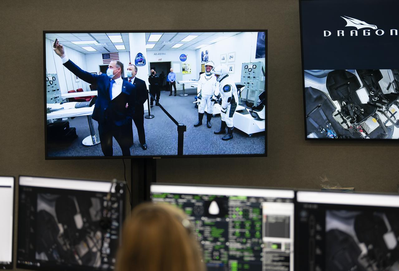 NASA Administrator Jim Bridenstine and NASA Deputy Administrator Jim Morhard are seen on a monitor inside firing room four taking a selfie with NASA astronauts Robert Behnken and Douglas Hurley before they departed the Neil A. Armstrong Operations and Checkout Building for Launch Complex 39A to board a SpaceX Crew Dragon spacecraft atop the company’s Falcon 9 rocket for NASA’s SpaceX Demo-2 mission, Saturday, May 30, 2020, in the Launch Control Center at NASA’s Kennedy Space Center in Florida. NASA’s SpaceX Demo-2 mission is the first launch with astronauts of the SpaceX Crew Dragon spacecraft and Falcon 9 rocket to the International Space Station as part of the agency’s Commercial Crew Program. The test flight serves as an end-to-end demonstration of SpaceX’s crew transportation system. Behnken and Hurley launched at 3:22 p.m. EDT on Saturday, May 30, from Launch Complex 39A at the Kennedy Space Center. A new era of human spaceflight is set to begin as American astronauts once again launch on an American rocket from American soil to low-Earth orbit for the first time since the conclusion of the Space Shuttle Program in 2011. Photo Credit: (NASA/Joel Kowsky)