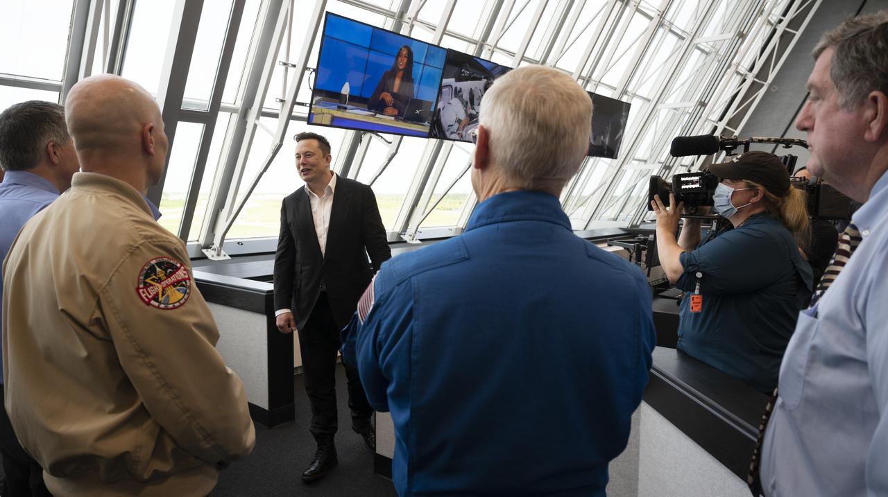 Elon Musk, SpaceX Chief Engineer, speaks with NASA managers following the launch of a SpaceX Falcon 9 rocket carrying the company's Crew Dragon spacecraft on the Demo-2 mission with NASA astronauts Douglas Hurley and Robert Behnken onboard, Saturday, May 30, 2020, in  firing room four of the Launch Control Center at NASA’s Kennedy Space Center in Florida. NASA’s SpaceX Demo-2 mission is the first launch with astronauts of the SpaceX Crew Dragon spacecraft and Falcon 9 rocket to the International Space Station as part of the agency’s Commercial Crew Program. The test flight serves as an end-to-end demonstration of SpaceX’s crew transportation system. Behnken and Hurley launched at 3:22 p.m. EDT on Saturday, May 30, from Launch Complex 39A at the Kennedy Space Center. A new era of human spaceflight is set to begin as American astronauts once again launch on an American rocket from American soil to low-Earth orbit for the first time since the conclusion of the Space Shuttle Program in 2011. Photo Credit: (NASA/Joel Kowsky)