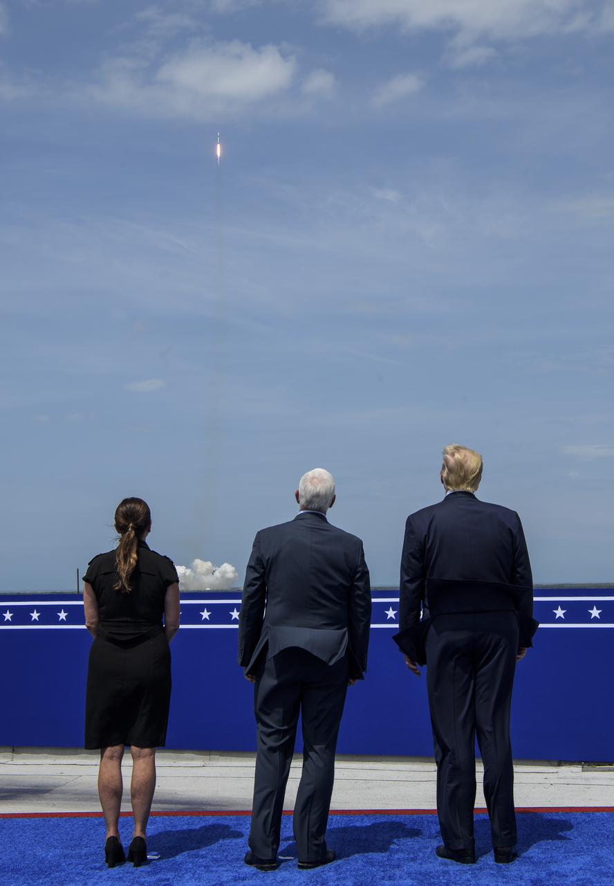 President Donald Trump, right, Vice President Mike Pence, and Second Lady Karen Pence watch the launch of a SpaceX Falcon 9 rocket carrying the company's Crew Dragon spacecraft on NASA’s SpaceX Demo-2 mission with NASA astronauts Robert Behnken and Douglas Hurley onboard, Saturday, May 30, 2020, from the balcony of  Operations Support Building II at NASA’s Kennedy Space Center in Florida. NASA’s SpaceX Demo-2 mission is the first launch with astronauts of the SpaceX Crew Dragon spacecraft and Falcon 9 rocket to the International Space Station as part of the agency’s Commercial Crew Program. The test flight serves as an end-to-end demonstration of SpaceX’s crew transportation system. Behnken and Hurley launched at 3:22 p.m. EDT on Saturday, May 30, from Launch Complex 39A at the Kennedy Space Center. A new era of human spaceflight is set to begin as American astronauts once again launch on an American rocket from American soil to low-Earth orbit for the first time since the conclusion of the Space Shuttle Program in 2011. Photo Credit: (NASA/Bill Ingalls)