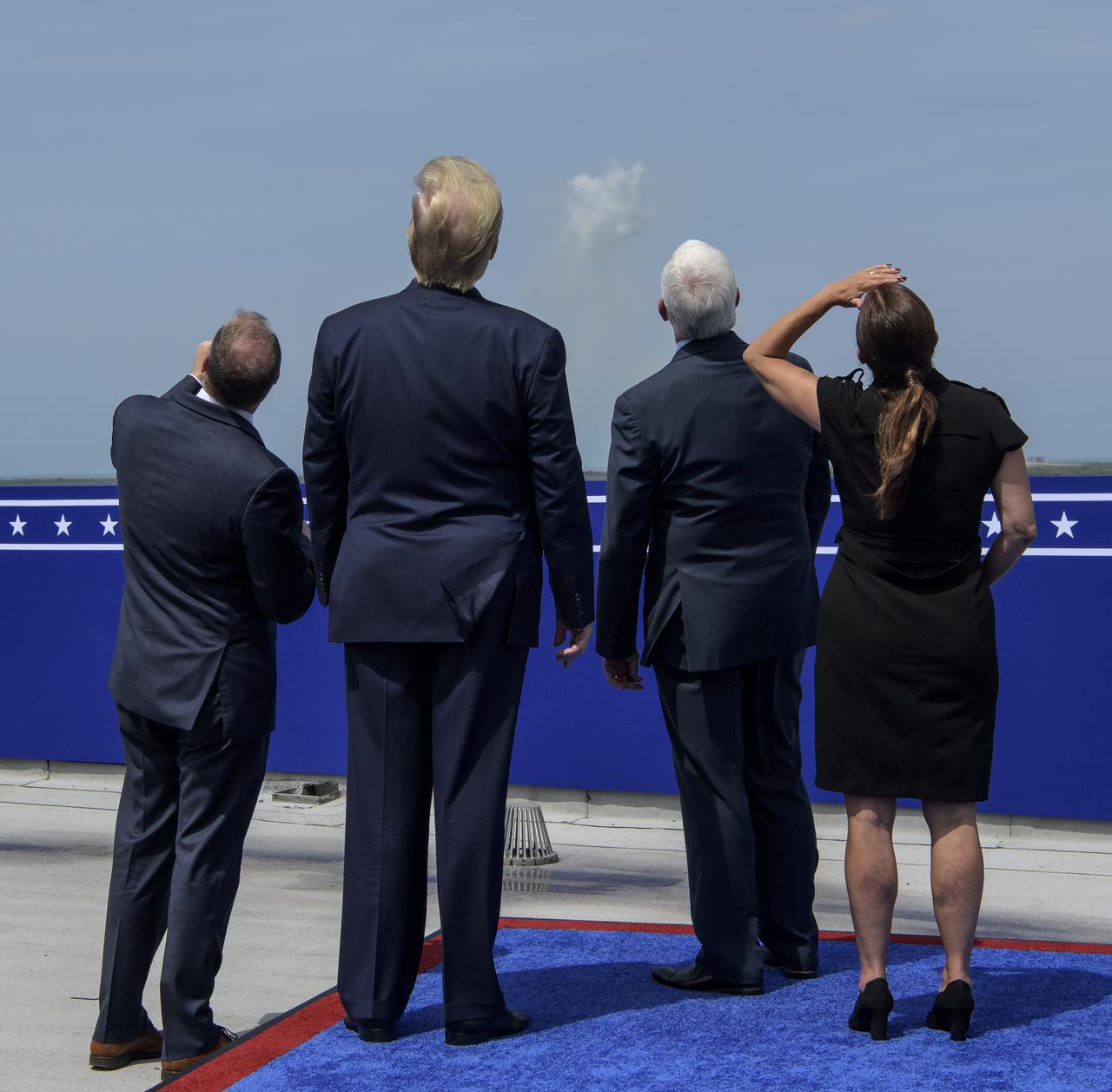 NASA Administrator Jim Bridenstine, left, President Donald Trump, Vice President Mike Pence, and Second Lady Karen Pence watch the launch of a SpaceX Falcon 9 rocket carrying the company's Crew Dragon spacecraft on NASA’s SpaceX Demo-2 mission with NASA astronauts Robert Behnken and Douglas Hurley onboard, Saturday, May 30, 2020, from the balcony of Operations Support Building II at NASA’s Kennedy Space Center in Florida. NASA’s SpaceX Demo-2 mission is the first launch with astronauts of the SpaceX Crew Dragon spacecraft and Falcon 9 rocket to the International Space Station as part of the agency’s Commercial Crew Program. The test flight serves as an end-to-end demonstration of SpaceX’s crew transportation system. Behnken and Hurley launched at 3:22 p.m. EDT on Saturday, May 30, from Launch Complex 39A at the Kennedy Space Center. A new era of human spaceflight is set to begin as American astronauts once again launch on an American rocket from American soil to low-Earth orbit for the first time since the conclusion of the Space Shuttle Program in 2011. Photo Credit: (NASA/Bill Ingalls)