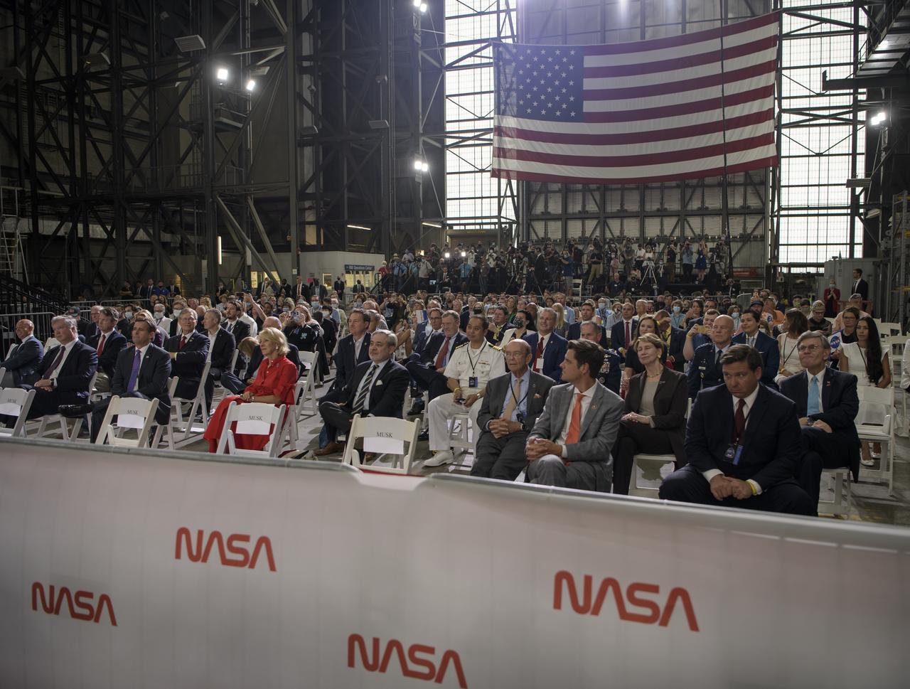 Guest wait to hear President Donald Trump give remarks inside the Vehicle Assembly Building following the launch of a SpaceX Falcon 9 rocket carrying the company's Crew Dragon spacecraft on NASA’s SpaceX Demo-2 mission with NASA astronauts Robert Behnken and Douglas Hurley onboard, Saturday, May 30, 2020, at NASA’s Kennedy Space Center in Florida. NASA’s SpaceX Demo-2 mission is the first launch with astronauts of the SpaceX Crew Dragon spacecraft and Falcon 9 rocket to the International Space Station as part of the agency’s Commercial Crew Program. The test flight serves as an end-to-end demonstration of SpaceX’s crew transportation system. Behnken and Hurley launched at 3:22 p.m. EDT on Saturday, May 30, from Launch Complex 39A at the Kennedy Space Center. A new era of human spaceflight is set to begin as American astronauts once again launch on an American rocket from American soil to low-Earth orbit for the first time since the conclusion of the Space Shuttle Program in 2011. Photo Credit: (NASA/Bill Ingalls)
