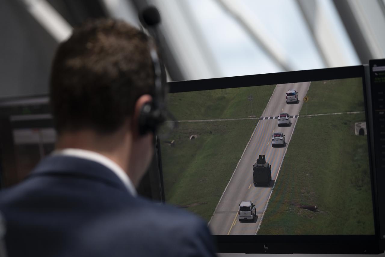 The convoy carrying NASA astronauts Robert Behnken and Douglas Hurley is seen through the windows of firing room four as it makes its way to Launch Complex 39A, Saturday, May 30, 2020, in firing room four of the Launch Control Center at NASA’s Kennedy Space Center in Florida. NASA’s SpaceX Demo-2 mission is the first launch with astronauts of the SpaceX Crew Dragon spacecraft and Falcon 9 rocket to the International Space Station as part of the agency’s Commercial Crew Program. The test flight serves as an end-to-end demonstration of SpaceX’s crew transportation system. Behnken and Hurley launched at 3:22 p.m. EDT on Saturday, May 30, from Launch Complex 39A at the Kennedy Space Center. A new era of human spaceflight is set to begin as American astronauts once again launch on an American rocket from American soil to low-Earth orbit for the first time since the conclusion of the Space Shuttle Program in 2011. Photo Credit: (NASA/Joel Kowsky)