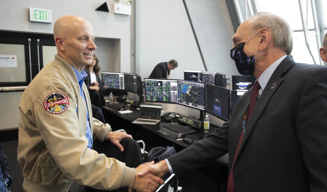 Stephen Koerner, Director of the Flight Operations Directorate at NASA’s Johnson Space Center, shakes hands with NASA Associate Administrator Steve Jurczyk following the launch of a SpaceX Falcon 9 rocket carrying the company's Crew Dragon spacecraft on the Demo-2 mission with NASA astronauts Douglas Hurley and Robert Behnken onboard, Saturday, May 30, 2020, in  firing room four of the Launch Control Center at NASA’s Kennedy Space Center in Florida. NASA’s SpaceX Demo-2 mission is the first launch with astronauts of the SpaceX Crew Dragon spacecraft and Falcon 9 rocket to the International Space Station as part of the agency’s Commercial Crew Program. The test flight serves as an end-to-end demonstration of SpaceX’s crew transportation system. Behnken and Hurley launched at 3:22 p.m. EDT on Saturday, May 30, from Launch Complex 39A at the Kennedy Space Center. A new era of human spaceflight is set to begin as American astronauts once again launch on an American rocket from American soil to low-Earth orbit for the first time since the conclusion of the Space Shuttle Program in 2011. Photo Credit: (NASA/Joel Kowsky)