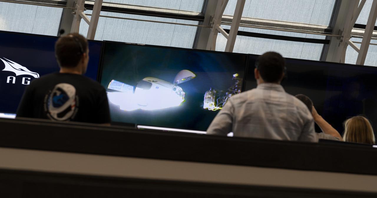A view of SpaceX’s Crew Dragon spacecraft with NASA astronauts Douglas Hurley and Robert Behnken onboard are seen on monitors inside firing room four as the spacecraft approaches to the International Space Station for docking, Sunday, May 31, 2020, in  firing room four of the Launch Control Center at NASA’s Kennedy Space Center in Florida. NASA’s SpaceX Demo-2 mission is the first launch with astronauts of the SpaceX Crew Dragon spacecraft and Falcon 9 rocket to the International Space Station as part of the agency’s Commercial Crew Program. The test flight serves as an end-to-end demonstration of SpaceX’s crew transportation system. Behnken and Hurley launched at 3:22 p.m. EDT on Saturday, May 30, from Launch Complex 39A at the Kennedy Space Center and docked with the International Space Station at 10:16am EDT on Sunday, May 31.. A new era of human spaceflight is set to begin as American astronauts once again launch on an American rocket from American soil to low-Earth orbit for the first time since the conclusion of the Space Shuttle Program in 2011. Photo Credit: (NASA/Joel Kowsky)