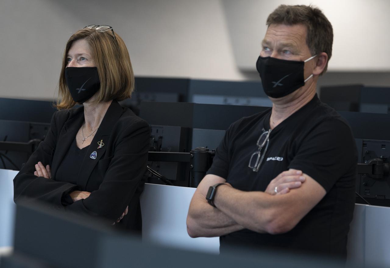 Kathy Lueders, manager of NASA's Commercial Crew Program, left, and Hans Koenigsmann, vice president for build and flight reliability at SpaceX, watch as the hatches are opened between SpaceX’s Crew Dragon spacecraft with NASA astronauts Douglas Hurley and Robert Behnken onboard and the International Space Station, Sunday, May 31, 2020, in  firing room four of the Launch Control Center at NASA’s Kennedy Space Center in Florida. NASA’s SpaceX Demo-2 mission is the first launch with astronauts of the SpaceX Crew Dragon spacecraft and Falcon 9 rocket to the International Space Station as part of the agency’s Commercial Crew Program. The test flight serves as an end-to-end demonstration of SpaceX’s crew transportation system. Behnken and Hurley launched at 3:22 p.m. EDT on Saturday, May 30, from Launch Complex 39A at the Kennedy Space Center and docked with the International Space Station at 10:16am EDT on Sunday, May 31.. A new era of human spaceflight is set to begin as American astronauts once again launch on an American rocket from American soil to low-Earth orbit for the first time since the conclusion of the Space Shuttle Program in 2011. Photo Credit: (NASA/Joel Kowsky)