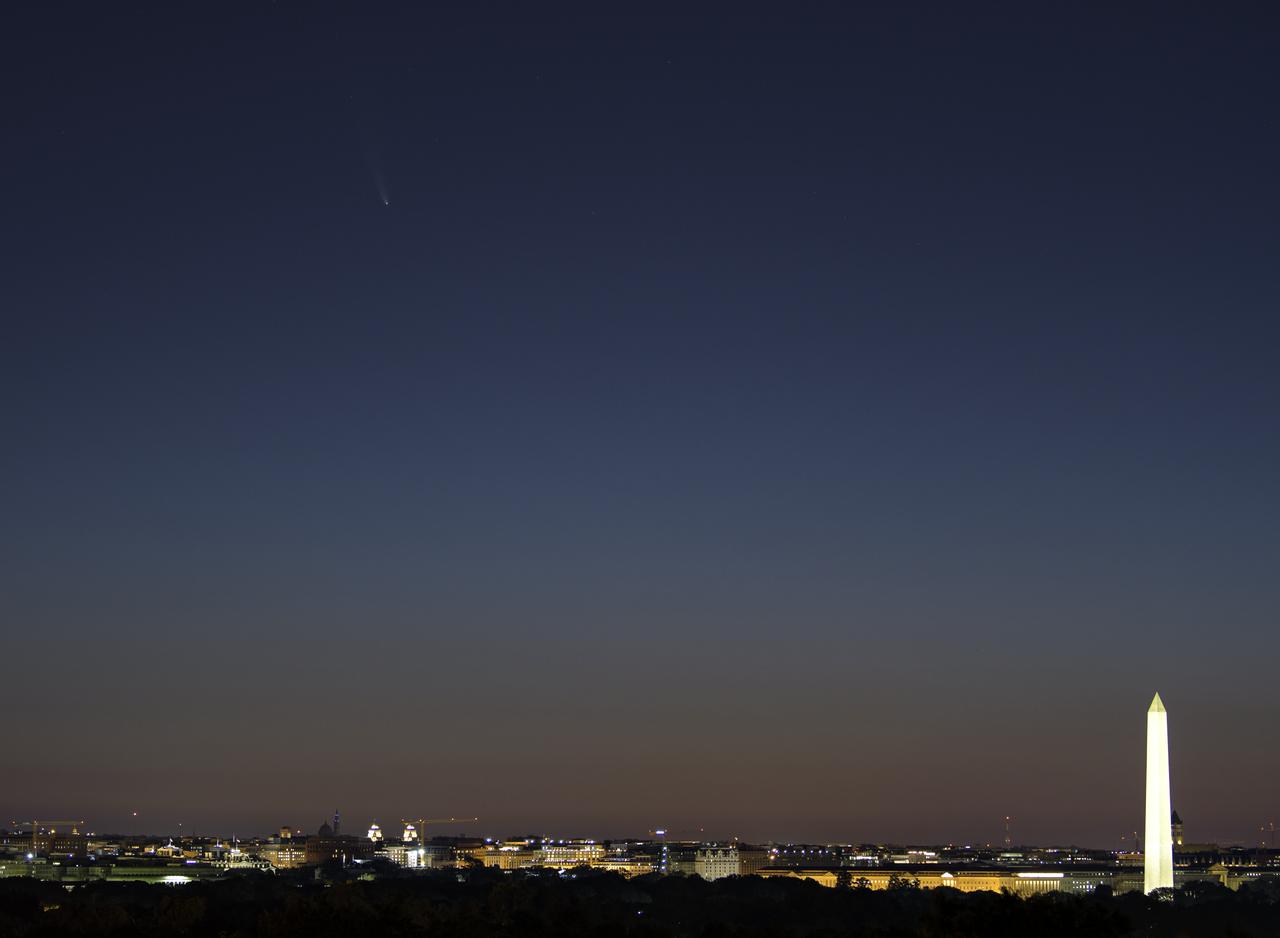 Comet NEOWISE is seen before sunrise, upper left, over Washington, Sunday, July 12, 2020. The comet was discovered by NASA’s Near-Earth Object Wide-field Infrared Survey Explorer, or NEOWISE, on March 27. Since then, the comet — called comet C/2020 F3 NEOWISE and nicknamed comet NEOWISE — has been spotted by several NASA spacecraft, including Parker Solar Probe, NASA’s Solar and Terrestrial Relations Observatory, the ESA/NASA Solar and Heliospheric Observatory, and astronauts aboard the International Space Station. Photo Credit: (NASA/Bill Ingalls)