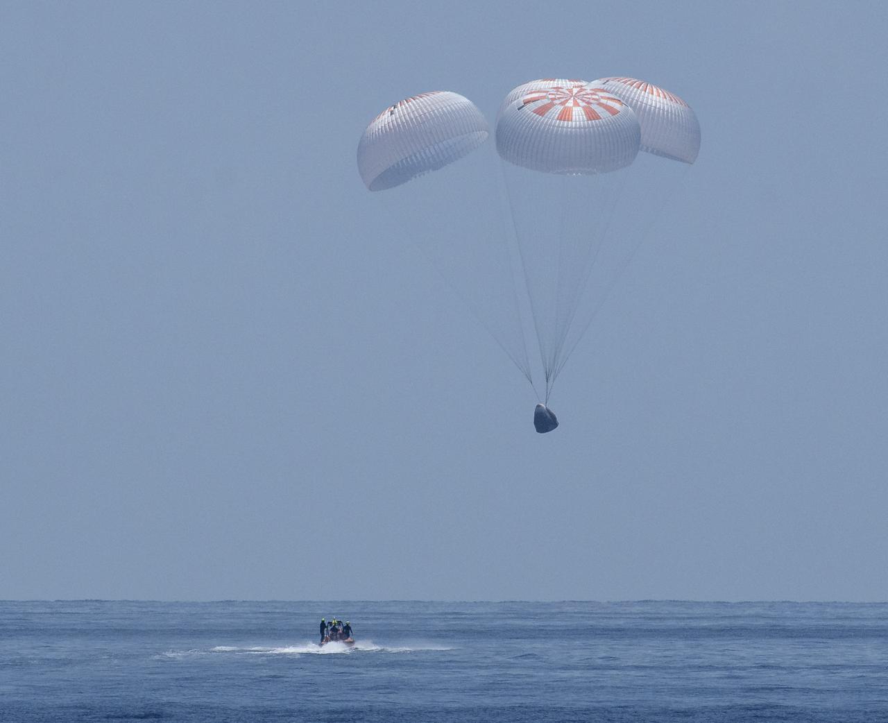 The SpaceX Crew Dragon Endeavour spacecraft is seen as it lands with NASA astronauts Robert Behnken and Douglas Hurley onboard in the Gulf of Mexico off the coast of Pensacola, Florida, Sunday, Aug. 2, 2020. The Demo-2 test flight for NASA's Commercial Crew Program was the first to deliver astronauts to the International Space Station and return them safely to Earth onboard a commercially built and operated spacecraft. Behnken and Hurley returned after spending 64 days in space. Photo Credit: (NASA/Bill Ingalls)