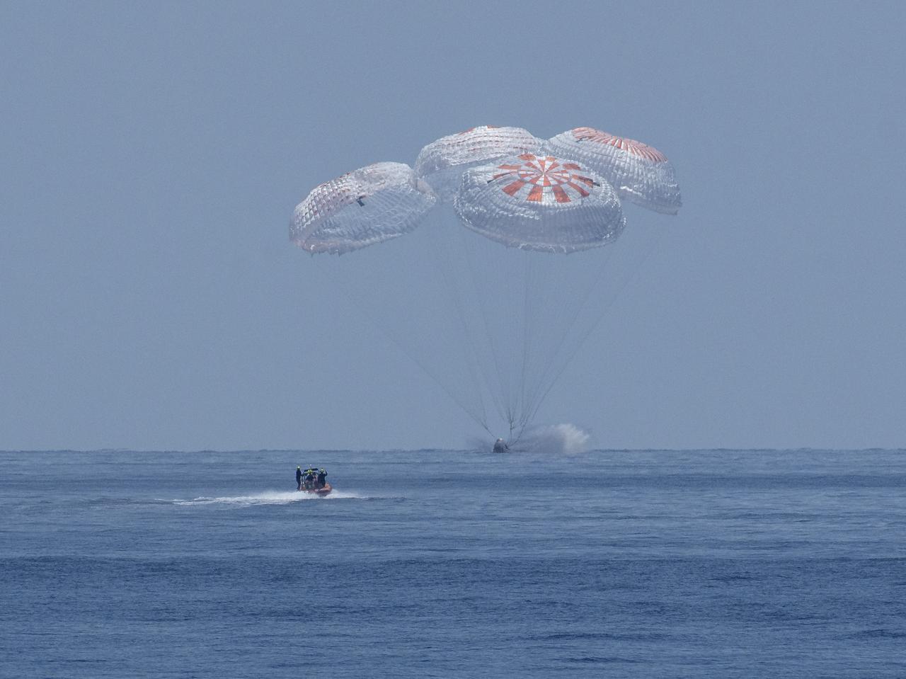 The SpaceX Crew Dragon Endeavour spacecraft is seen as it lands with NASA astronauts Robert Behnken and Douglas Hurley onboard in the Gulf of Mexico off the coast of Pensacola, Florida, Sunday, Aug. 2, 2020. The Demo-2 test flight for NASA's Commercial Crew Program was the first to deliver astronauts to the International Space Station and return them safely to Earth onboard a commercially built and operated spacecraft. Behnken and Hurley returned after spending 64 days in space. Photo Credit: (NASA/Bill Ingalls)