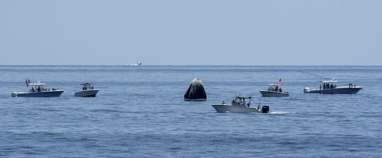 Support teams and curious recreational boaters arrive at the SpaceX Crew Dragon Endeavour spacecraft shortly after it landed with NASA astronauts Robert Behnken and Douglas Hurley onboard in the Gulf of Mexico off the coast of Pensacola, Florida, Sunday, Aug. 2, 2020. The Demo-2 test flight for NASA's Commercial Crew Program was the first to deliver astronauts to the International Space Station and return them safely to Earth onboard a commercially built and operated spacecraft. Behnken and Hurley returned after spending 64 days in space. Photo Credit: (NASA/Bill Ingalls)