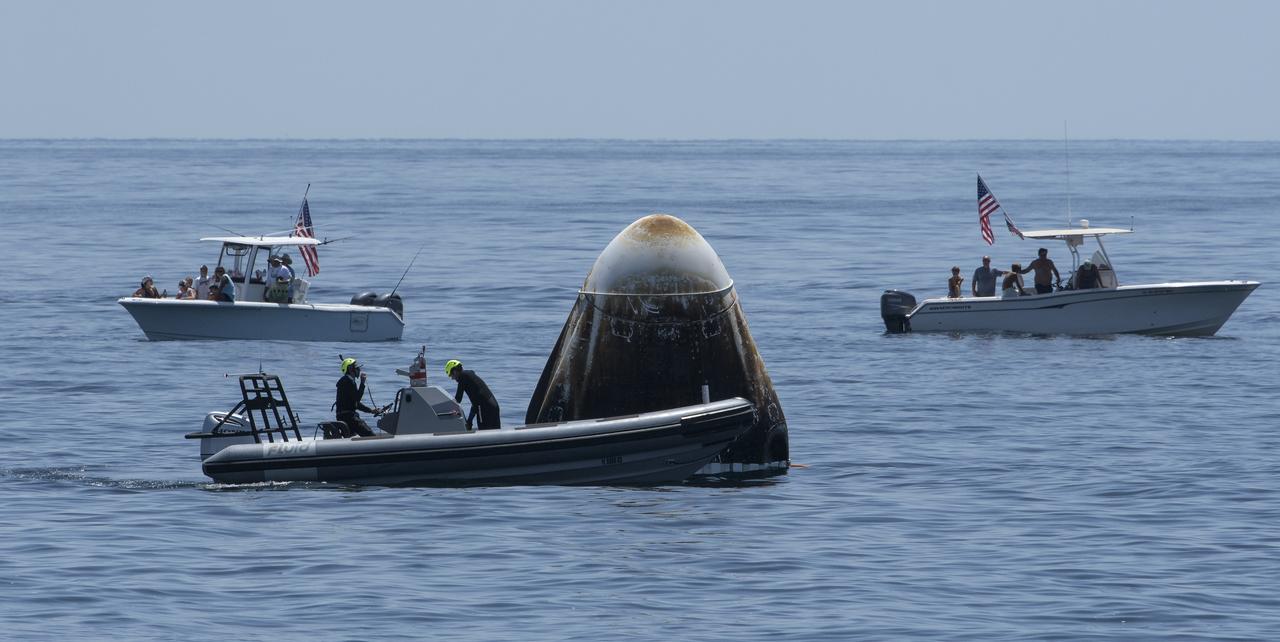 Support teams and curious recreational boaters arrive at the SpaceX Crew Dragon Endeavour spacecraft shortly after it landed with NASA astronauts Robert Behnken and Douglas Hurley onboard in the Gulf of Mexico off the coast of Pensacola, Florida, Sunday, Aug. 2, 2020. The Demo-2 test flight for NASA's Commercial Crew Program was the first to deliver astronauts to the International Space Station and return them safely to Earth onboard a commercially built and operated spacecraft. Behnken and Hurley returned after spending 64 days in space. Photo Credit: (NASA/Bill Ingalls)