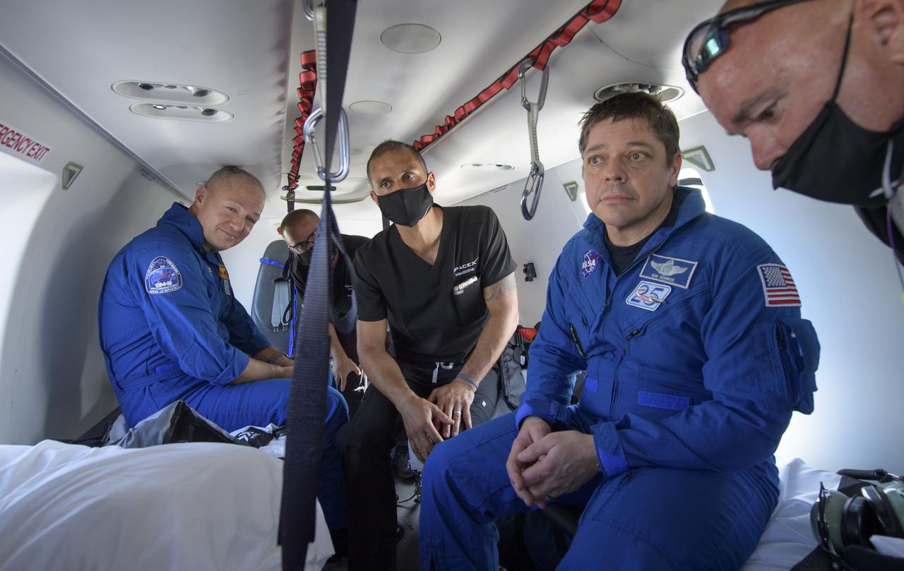 NASA astronauts Douglas Hurley, left, and Robert Behnken prepare to depart their helicopter at Naval Air Station Pensacola after the duo landed in their SpaceX Crew Dragon Endeavour spacecraft in the Gulf of Mexico off the coast of Pensacola, Florida, Sunday, Aug. 2, 2020. The Demo-2 test flight for NASA's Commercial Crew Program was the first to deliver astronauts to the International Space Station and return them safely to Earth onboard a commercially built and operated spacecraft. Behnken and Hurley returned after spending 64 days in space. Photo Credit: (NASA/Bill Ingalls)