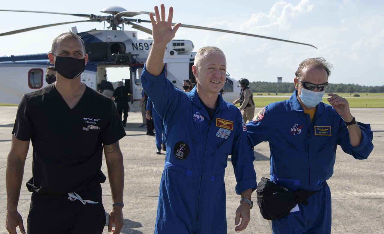 NASA astronaut Douglas Hurley waves to onlookers as he boards a plane at Naval Air Station Pensacola to return him and NASA astronaut Robert Behnken home to Houston a few hours after the duo landed in their SpaceX Crew Dragon Endeavour spacecraft off the coast of Pensacola, Florida, Sunday, Aug. 2, 2020. The Demo-2 test flight for NASA's Commercial Crew Program was the first to deliver astronauts to the International Space Station and return them safely to Earth onboard a commercially built and operated spacecraft. Behnken and Hurley returned after spending 64 days in space. Photo Credit: (NASA/Bill Ingalls)