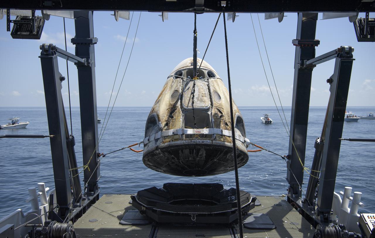 The SpaceX Crew Dragon Endeavour spacecraft is lifted onto the SpaceX GO Navigator recovery ship shortly after it landed with NASA astronauts Robert Behnken and Douglas Hurley onboard in the Gulf of Mexico off the coast of Pensacola, Florida, Sunday, Aug. 2, 2020. The Demo-2 test flight for NASA's Commercial Crew Program was the first to deliver astronauts to the International Space Station and return them safely to Earth onboard a commercially built and operated spacecraft. Behnken and Hurley returned after spending 64 days in space. Photo Credit: (NASA/Bill Ingalls)