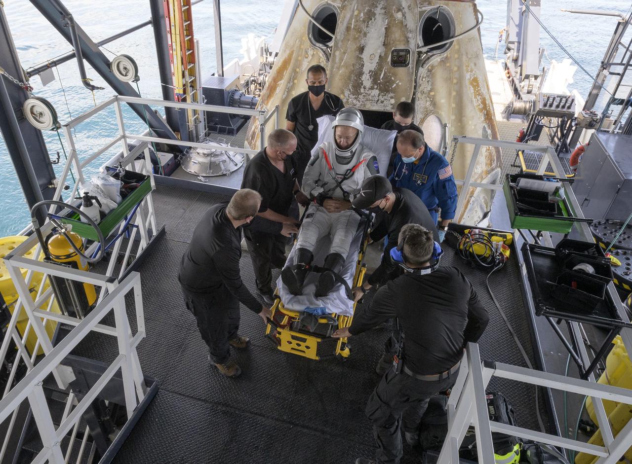 NASA astronaut Douglas Hurley is helped out of the SpaceX Crew Dragon Endeavour spacecraft onboard the SpaceX GO Navigator recovery ship after he and NASA astronaut Robert Behnken landed in the Gulf of Mexico off the coast of Pensacola, Florida, Sunday, Aug. 2, 2020. The Demo-2 test flight for NASA's Commercial Crew Program was the first to deliver astronauts to the International Space Station and return them safely to Earth onboard a commercially built and operated spacecraft. Behnken and Hurley returned after spending 64 days in space. Photo Credit: (NASA/Bill Ingalls)