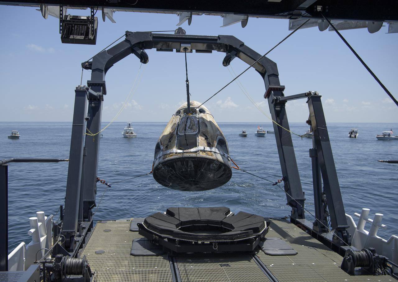 The SpaceX Crew Dragon Endeavour spacecraft is lifted onto the SpaceX GO Navigator recovery ship shortly after it landed with NASA astronauts Robert Behnken and Douglas Hurley onboard in the Gulf of Mexico off the coast of Pensacola, Florida, Sunday, Aug. 2, 2020. The Demo-2 test flight for NASA's Commercial Crew Program was the first to deliver astronauts to the International Space Station and return them safely to Earth onboard a commercially built and operated spacecraft. Behnken and Hurley returned after spending 64 days in space. Photo Credit: (NASA/Bill Ingalls)
