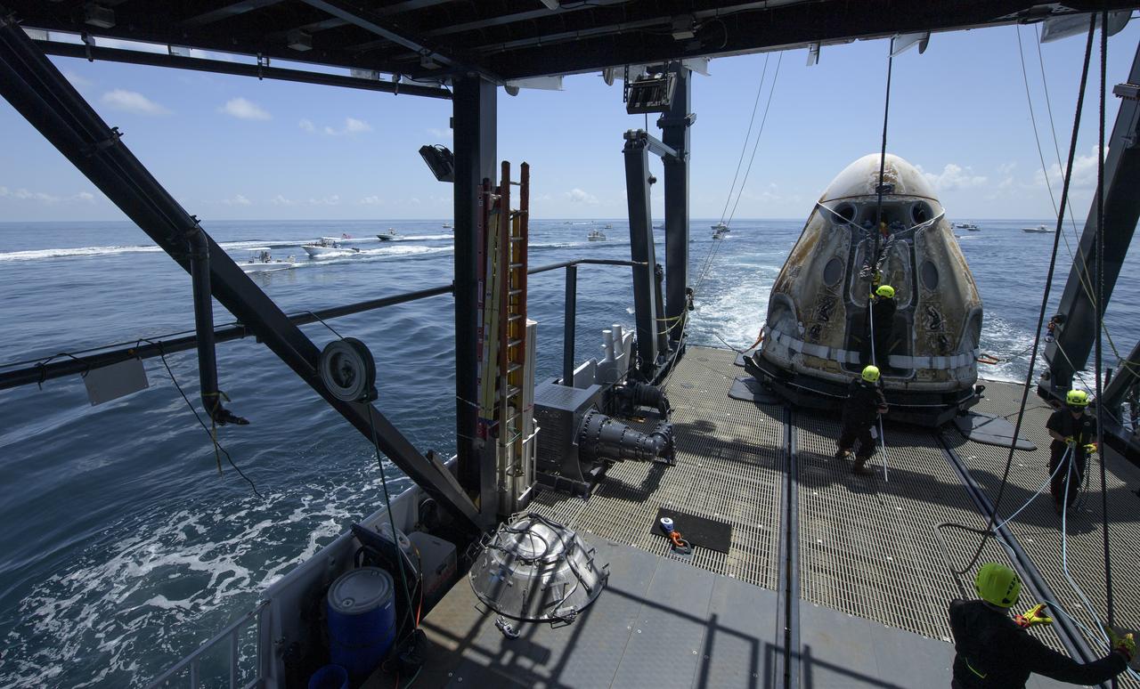 The SpaceX Crew Dragon Endeavour spacecraft is lowered onto the SpaceX GO Navigator recovery ship shortly after it landed with NASA astronauts Robert Behnken and Douglas Hurley onboard in the Gulf of Mexico off the coast of Pensacola, Florida, Sunday, Aug. 2, 2020. The Demo-2 test flight for NASA's Commercial Crew Program was the first to deliver astronauts to the International Space Station and return them safely to Earth onboard a commercially built and operated spacecraft. Behnken and Hurley returned after spending 64 days in space. Photo Credit: (NASA/Bill Ingalls)