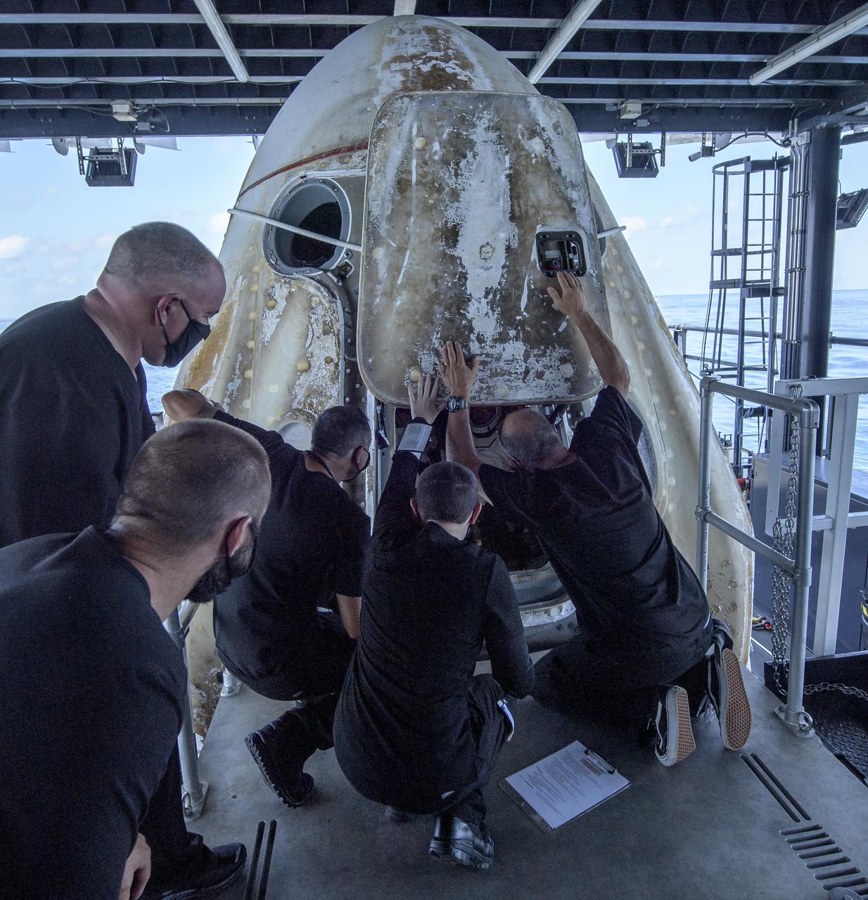 The hatch of the SpaceX Crew Dragon Endeavour spacecraft is opened for egress of NASA astronauts Robert Behnken and Douglas Hurley onboard the SpaceX GO Navigator recovery ship shortly the duo landed in the Gulf of Mexico off the coast of Pensacola, Florida, Sunday, Aug. 2, 2020. The Demo-2 test flight for NASA's Commercial Crew Program was the first to deliver astronauts to the International Space Station and return them safely to Earth onboard a commercially built and operated spacecraft. Behnken and Hurley returned after spending 64 days in space. Photo Credit: (NASA/Bill Ingalls)