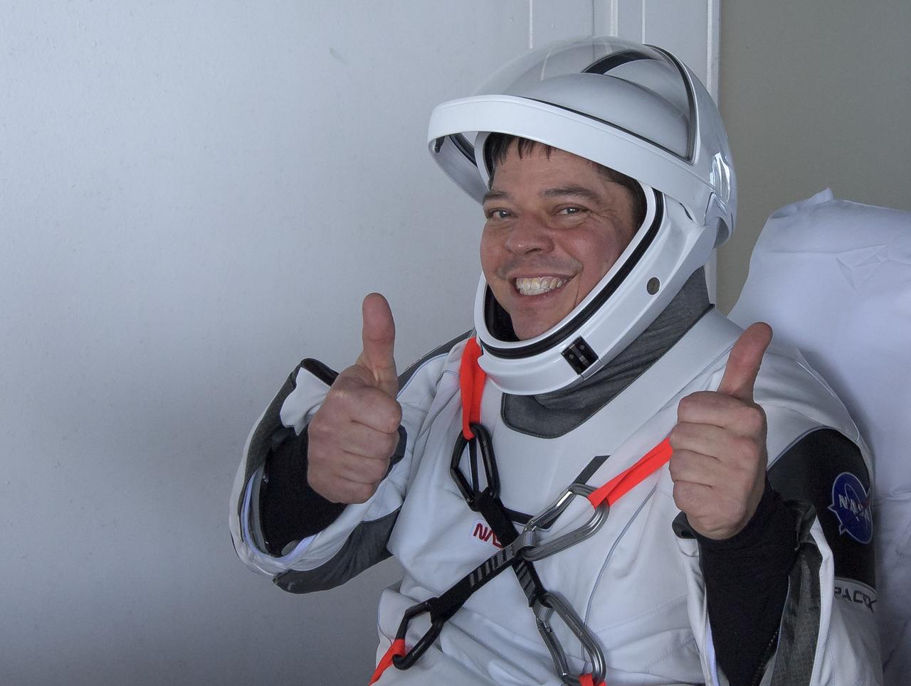NASA astronaut Robert Behnken gives a thumbs up after egressing the SpaceX Crew Dragon Endeavour spacecraft onboard the SpaceX GO Navigator recovery ship after he and NASA astronaut Douglas Hurley landed in the Gulf of Mexico off the coast of Pensacola, Florida, Sunday, Aug. 2, 2020. The Demo-2 test flight for NASA's Commercial Crew Program was the first to deliver astronauts to the International Space Station and return them safely to Earth onboard a commercially built and operated spacecraft. Behnken and Hurley returned after spending 64 days in space. Photo Credit: (NASA/Bill Ingalls)