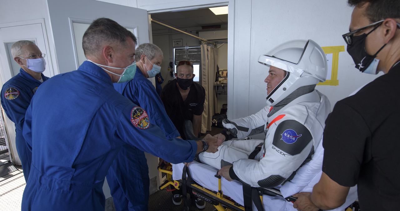 NASA astronaut Robert Behnken is greeted by NASA astronaut and Crew Recovery Chief Shane Kimbrough after egressing the SpaceX Crew Dragon Endeavour spacecraft onboard the SpaceX GO Navigator recovery ship after he and NASA astronaut Douglas Hurley landed in the Gulf of Mexico off the coast of Pensacola, Florida, Sunday, Aug. 2, 2020. The Demo-2 test flight for NASA's Commercial Crew Program was the first to deliver astronauts to the International Space Station and return them safely to Earth onboard a commercially built and operated spacecraft. Behnken and Hurley returned after spending 64 days in space. Photo Credit: (NASA/Bill Ingalls)
