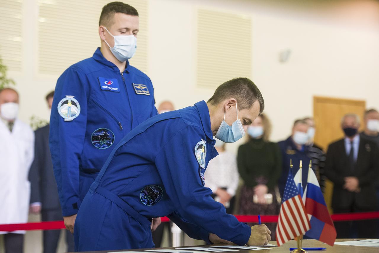 Expedition 64 crew member Sergey Ryzhikov of Roscosmos, signs in for Soyuz qualification exams as fellow crew member Sergey Kud-Sverchkov of Roscosmos looks on, Tuesday, Sept. 22, 2020 at the Gagarin Cosmonaut Training Center (GCTC) in Star City, Russia. Photo Credit: (NASA/GCTC/Andrey Shelepin)