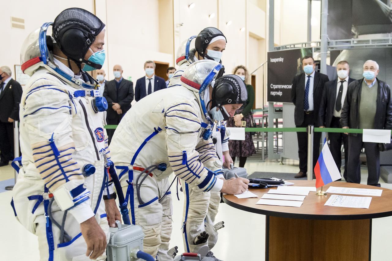 Expedition 64 backup crew member Oleg Novitskiy of Roscosmos signs in for Soyuz qualification exams while NASA astronaut Mark Vande Hei, left, and Russian cosmonaut Petr Dubrov of Roscosmos, right, look on, Tuesday, Sept. 22, 2020 at the Gagarin Cosmonaut Training Center (GCTC) in Star City, Russia. Photo Credit: (NASA/GCTC/Irina Spector)