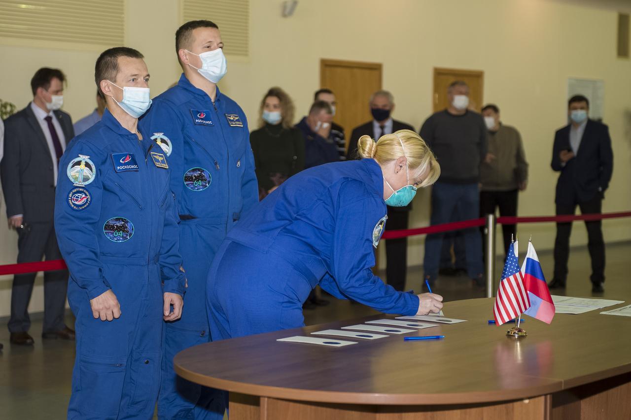 Expedition 64 crew member NASA astronaut Kate Rubins signs in for Soyuz qualification exams as Russian cosmonaut Sergey Ryzhikov of Roscosmos, left, and Russian cosmonaut Sergey Kud-Sverchkov of Roscosmos look on, Tuesday, Sept. 22, 2020 at the Gagarin Cosmonaut Training Center (GCTC) in Star City, Russia. Photo Credit: (NASA/GCTC/Irina Spector)