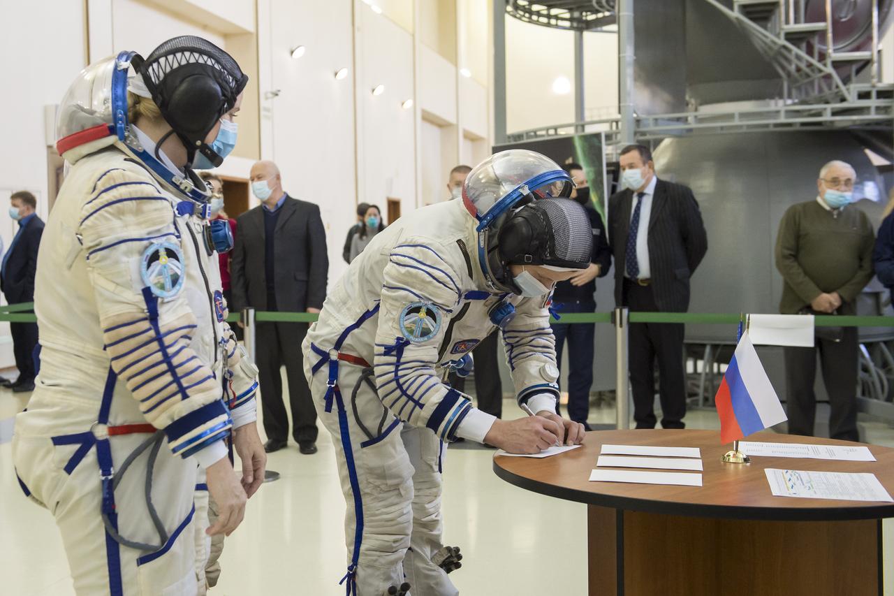 Expedition 64 crew member Sergey Kud-Sverchkov of Roscosmos signs in for Soyuz qualification exams, as crew mates Kate Rubins of NASA, left and Sergey Ryzhikov of Roscosmos look on, Wednesday, Sept. 23, 2020 at the Gagarin Cosmonaut Training Center (GCTC) in Star City, Russia. Photo Credit: (NASA/GCTC/Irina Spector)