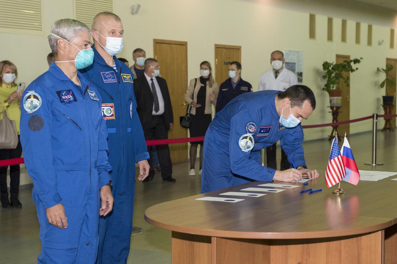 Expedition 64 backup crew member Petr Dubrov of Roscosmos signs in for his Soyuz qualification exams as crew mates Mark Vande Hei of NASA, left, and Oleg Novitskiy of Roscosmos look on, Wednesday, Sept. 23, 2020 at the Gagarin Cosmonaut Training Center (GCTC) in Star City, Russia. Photo Credit: (NASA/GCTC/Irina Spector)