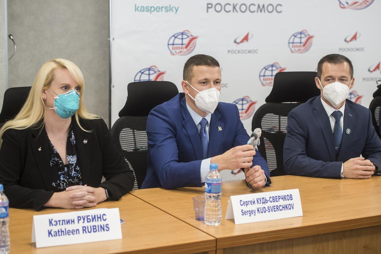 Expedition 64 crew members NASA astronaut Kate Rubins, left, Russian cosmonaut Sergey Kud-Sverchkov of Roscosmos, center, and Russian cosmonaut Sergey Ryzhikov of Roscosmos, listen during a press conference prior to their launch from the Baikonur Cosmodrome in Kazakhstan, Thursday, Sept. 24, 2020 at the Gagarin Cosmonaut Training Center (GCTC) in Star City, Russia. Kud-Sverchkov is holding a knit cosmonaut named Yuri that his wife made for him to take along for the launch. Photo Credit: (NASA/GCTC/Andrey Shelepin)