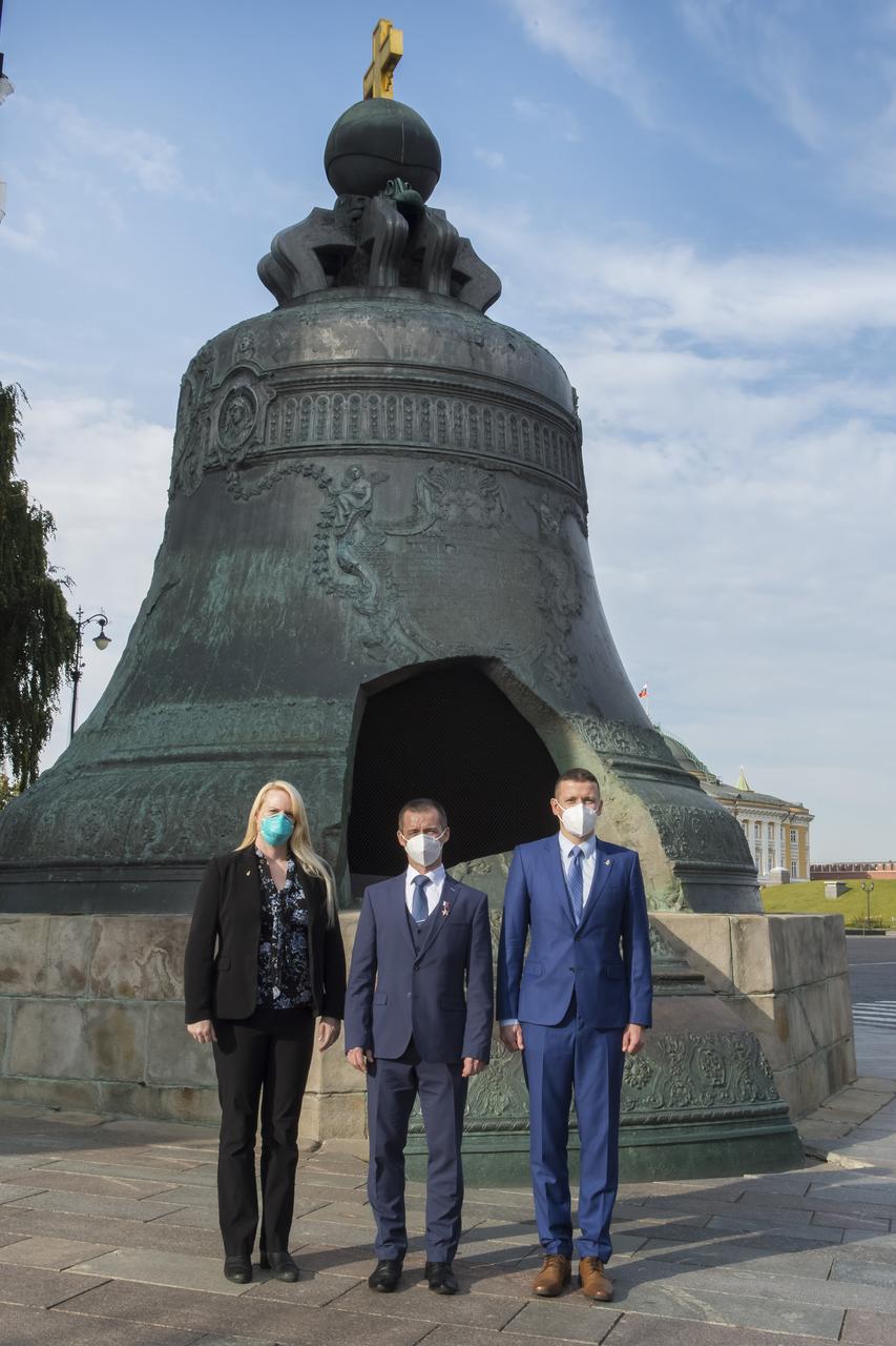 Expedition 64 prime crew members, NASA astronaut Kate Rubins, left, Russian cosmonaut Sergey Ryzhikov of Roscosmos, center, and Russian cosmonaut Sergey Kud-Sverchkov of Roscosmos pose for a photo in front of the Tsar Bell in Red Square after laying flowers at the site where Russian space icons are interred as part of traditional pre-launch ceremonies, Thursday, Sept. 24, 2020 in Moscow. Photo Credit: (NASA/GCTC/Irina Spector)