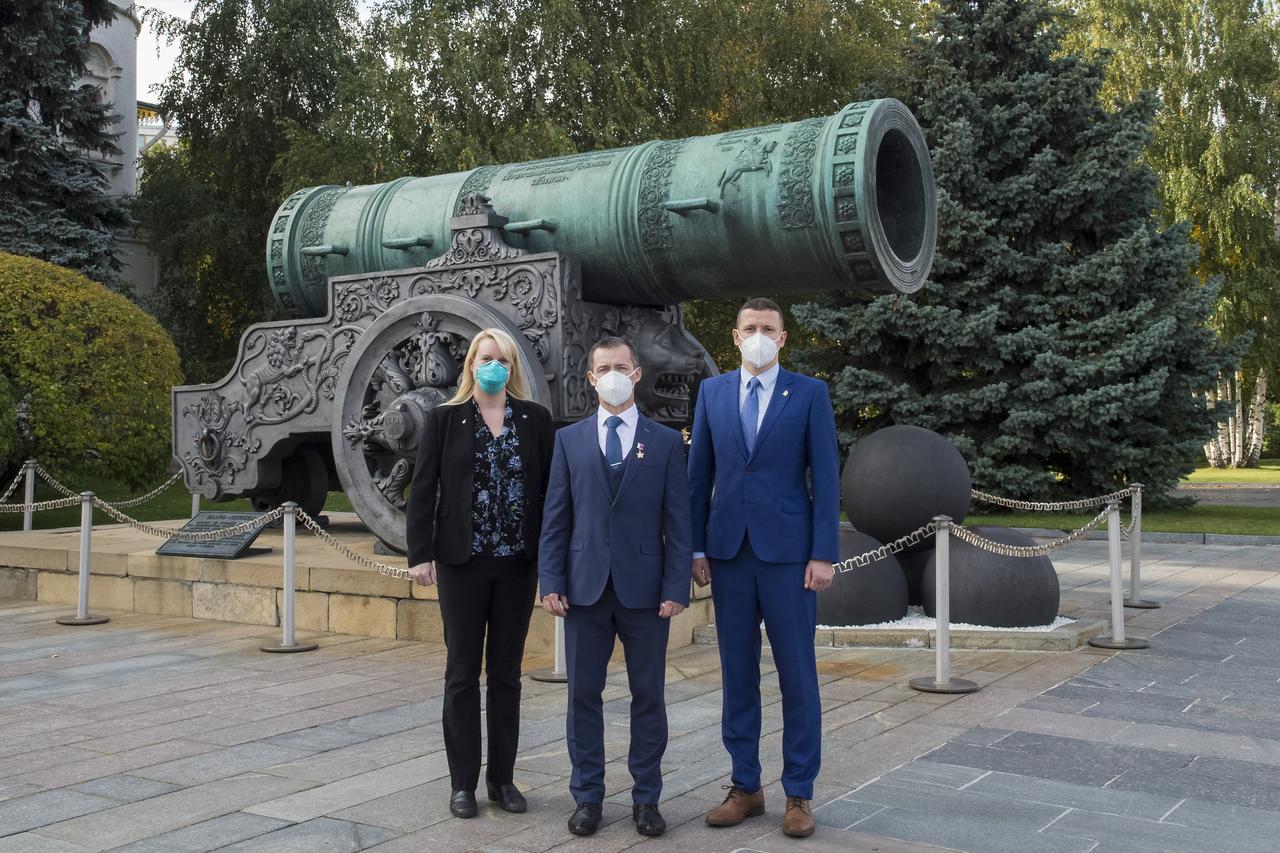 Expedition 64 prime crew members, NASA astronaut Kate Rubins, left, Russian cosmonaut Sergey Ryzhikov of Roscosmos, center, and Russian cosmonaut Sergey Kud-Sverchkov of Roscosmos pose for a photo in front of the Tsar Cannon in Red Square after laying flowers at the site where Russian space icons are interred as part of traditional pre-launch ceremonies, Thursday, Sept. 24, 2020 in Moscow. Photo Credit: (NASA/GCTC/Irina Spector)