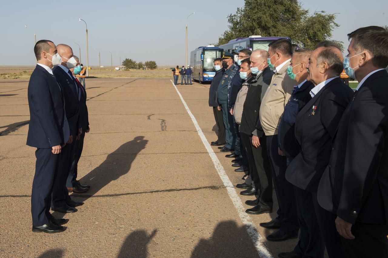 Expedition 64 backup crew members Russian cosmonaut Petr Dubrov of Roscosmos, left, Russian cosmonaut Oleg Novitskiy of Roscosmos, center, and NASA astronaut Mark Vande Hei, greet Russian officials after arriving in Baikonur, Kazakhstan from the Gagarin Cosmonaut Training Center, Sunday, Sept. 27, 2020. The prime crew is scheduled to launch from the Baikonur Cosmosdrome on a Soyuz rocket October 14. Photo Credit: (NASA/GCTC/Andrey Shelepin)