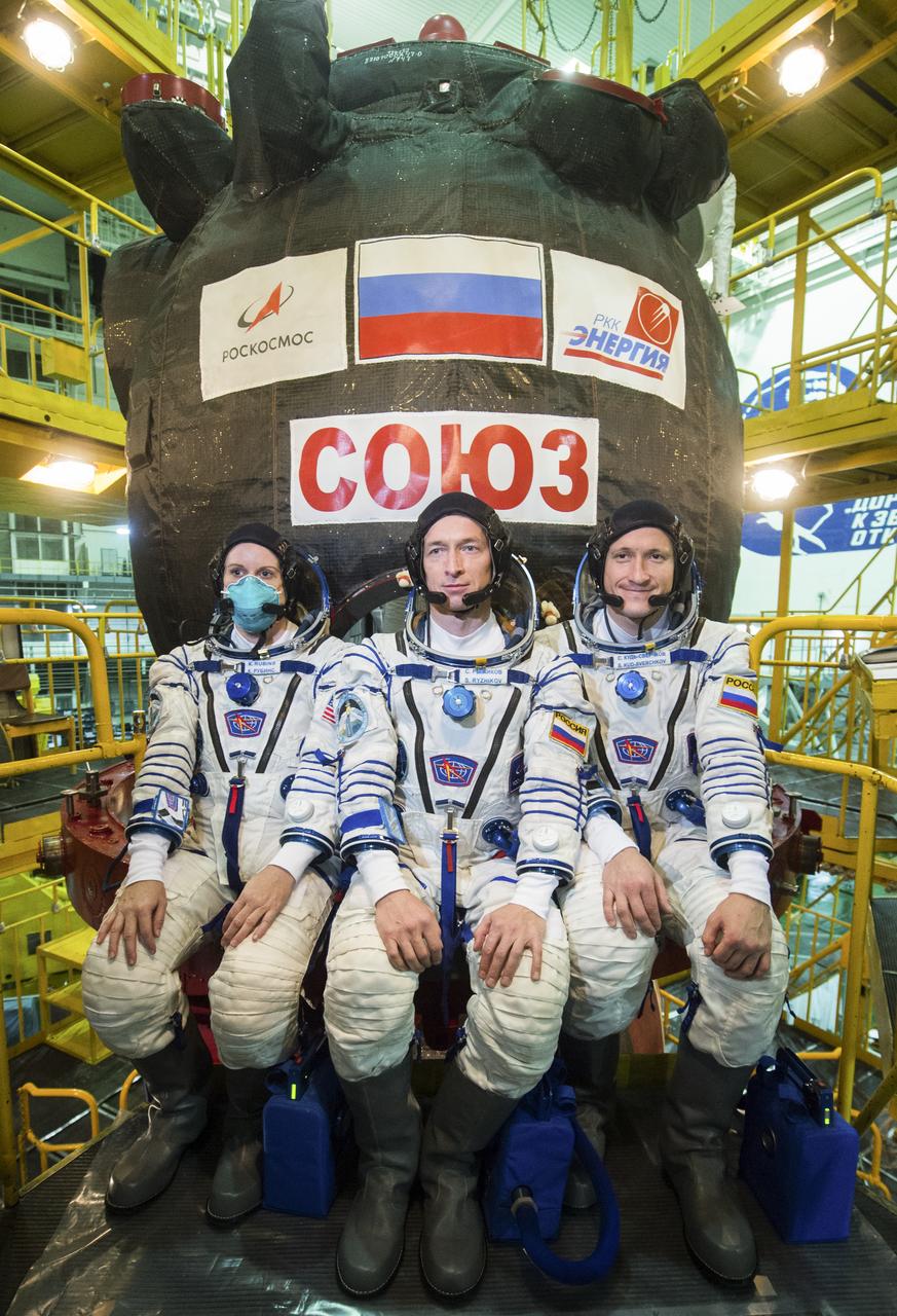 Expedition 64 NASA astronaut Kate Rubins, left, and Russian cosmonauts Sergey Ryzhikov, center, and Sergey Kud-Sverchkov, right, of Roscosmos take a moment during the Soyuz MS-17 spacecraft fit check to pose for a photograph, Monday, Sept. 28, 2020, at the Baikonur Cosmodrome in Kazakhstan. The trio are preparing for launch to the International Space Station in their Soyuz MS-17 spacecraft from the Baikonur Cosmodrome in Kazakhstan on October 14, Baikonur time. Photo Credit: (NASA/GCTC/Andrey Shelepin)