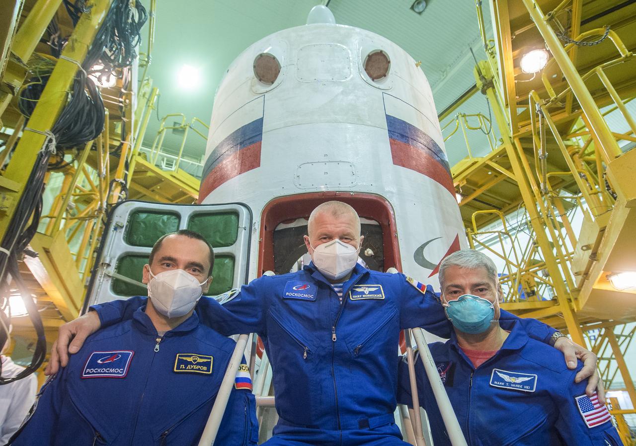 Expedition 64 backup crew members Petr Dubrov, left, and Oleg Novitskiy of Roscosmos, center, and Mark Vande Hei of NASA, right, pose for a picture during the Soyuz MS-17 spacecraft fit check, Wednesday, Oct. 7, 2020, at the Baikonur Cosmodrome in Kazakhstan. Expedition 64 Soyuz commander Sergey Ryzhikov of Roscosmos, flight engineer Sergey Kud-Sverchkov of Roscosmos, and flight engineer Kate Rubins of NASA, are scheduled to launch to the International Space Station aboard the Soyuz MS-17 spacecraft on October 14. Photo Credit: (NASA/GCTC/Andrey Shelepin)