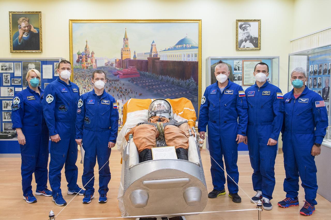 The Expedition 64 prime and backup crew members pose for a picture next to a replica of a Vostok seat and passenger at the Baikonur Cosmodrome Museum, Wednesday, Oct. 7, 2020, at the Baikonur Cosmodrome in Kazakhstan. From left to right are the prime crew members Kate Rubins of NASA, Sergey Kud-Sverchkov of Roscosmos, and Sergey Ryzhikov of Roscosmos, and backup crew members Oleg Novitskiy of Roscosmos, Petr Dubrov of Roscosmos, and Mark Vande Hei of NASA. Rubins, Kud-Sverchkov, and Ryzhikov are scheduled to launch to the International Space Station aboard the Soyuz MS-17 spacecraft on October 14. Photo Credit: (NASA/GCTC/Andrey Shelepin)