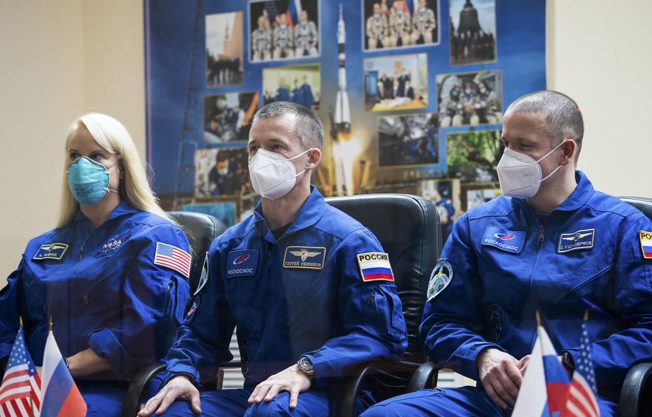 Expedition 64 prime crew members NASA astronaut Kate Rubins, left, and Russian cosmonauts Sergey Ryzhikov, center, and Sergey Kud-Sverchkov, right, of Roscosmos, are seen in quarantine, behind glass, during a press conference, Tuesday, Oct. 13, 2020, at the Cosmonaut Hotel in Baikonur, Kazakhstan. Rubins, Ryzhikov, and Kud-Sverchkov are scheduled to launch to the International Space Station aboard the Soyuz MS-17 spacecraft on October 14.  Photo Credit: (NASA/GCTC/Andrey Shelepin)