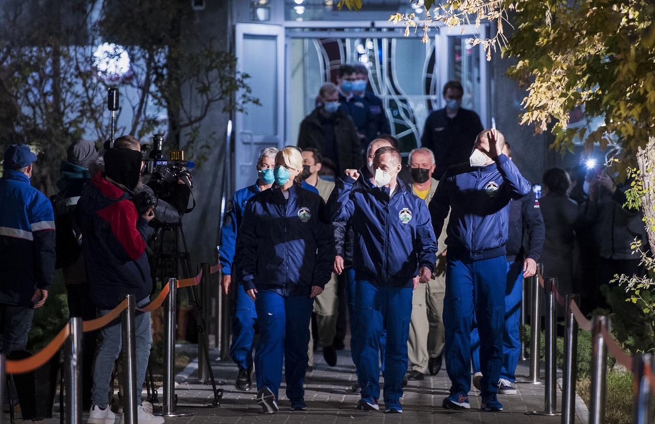 Expedition 64 NASA astronaut Kate Rubins, left, and Russian cosmonauts Sergey Ryzhikov, center, and Sergey Kud-Sverchkov, right, of Roscosmos, are seen as they depart the Cosmonaut Hotel to suit-up for their Soyuz launch to the International Space Station, Wednesday, Oct. 14, 2020, in Baikonur, Kazakhstan. Launch of the Soyuz MS-17 spacecraft with Ryzhikov, Kud-Sverchkov, and Rubins occurred at 1:45 a.m. EDT to begin their six-month mission onboard the International Space Station. Photo Credit: (NASA/GCTC/Andrey Shelepin)