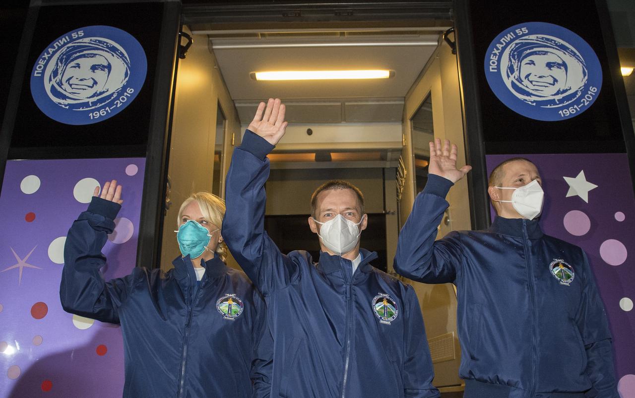 Expedition 64 NASA astronaut Kate Rubins, left, and Russian cosmonauts Sergey Ryzhikov, center, and Sergey Kud-Sverchkov, right, of Roscosmos, wave as they depart the Cosmonaut Hotel to suit-up for their Soyuz launch to the International Space Station, Wednesday, Oct. 14, 2020, in Baikonur, Kazakhstan. Launch of the Soyuz MS-17 spacecraft with Ryzhikov, Kud-Sverchkov, and Rubins occurred at 1:45 a.m. EDT to begin their six-month mission onboard the International Space Station. Photo Credit: (NASA/GCTC/Andrey Shelepin)