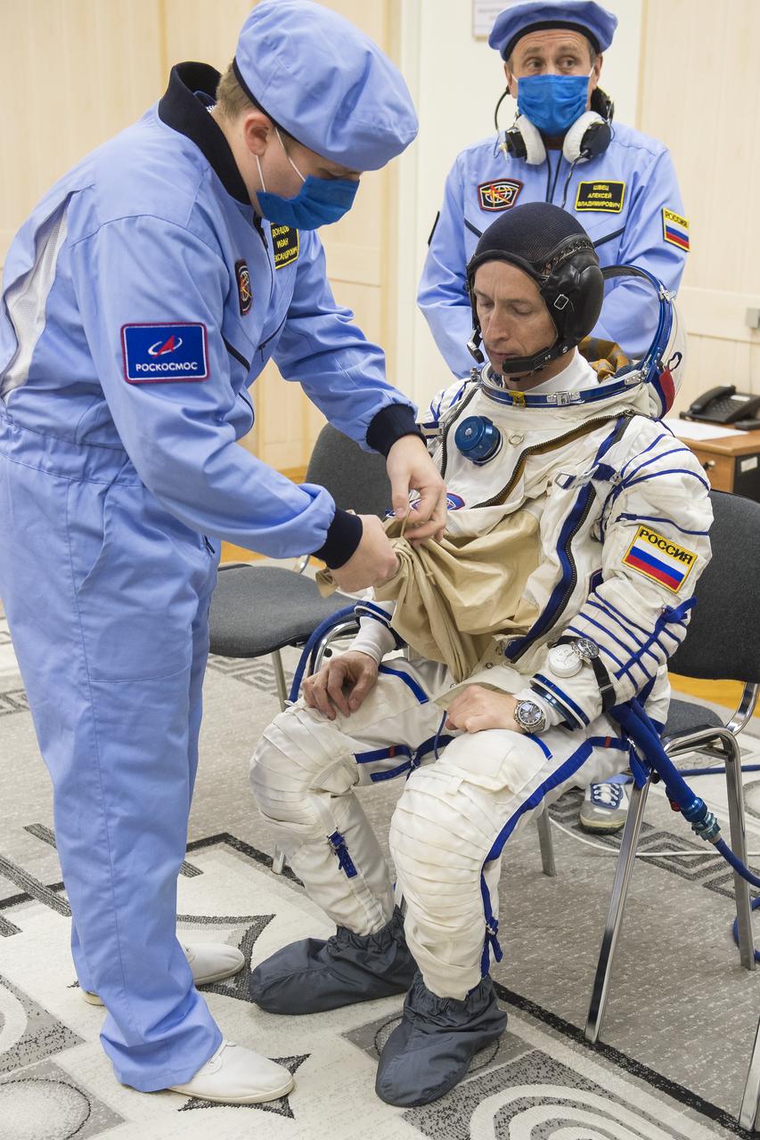 Expedition 64 Russian cosmonaut Sergey Ryzhikov of Roscosmos is helped into his Russian Sokol suit as he and fellow cremates, Sergey Kud-Sverchkov of Roscosmos and Kate Rubins of NASA prepare for their Soyuz launch to the International Space Station Wednesday, Oct. 14, 2020, at the Baikonur Cosmodrome in Kazakhstan.  The trio launched at 1:45 a.m. EDT to begin a six-month mission aboard the International Space Station. Photo Credit: (NASA/GCTC/Andrey Shelepin)
