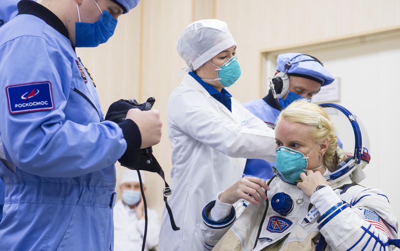 Expedition 64 NASA astronaut Kate Rubins is helped into her Russian Sokol suit as she and fellow cremates, Sergey Ryzhikov and Sergey Kud-Sverchkov of Roscosmos prepare for their Soyuz launch to the International Space Station Wednesday, Oct. 14, 2020, at the Baikonur Cosmodrome in Kazakhstan. The trio launched at 1:45 a.m. EDT to begin a six-month mission aboard the International Space Station. Photo Credit: (NASA/GCTC/Andrey Shelepin)