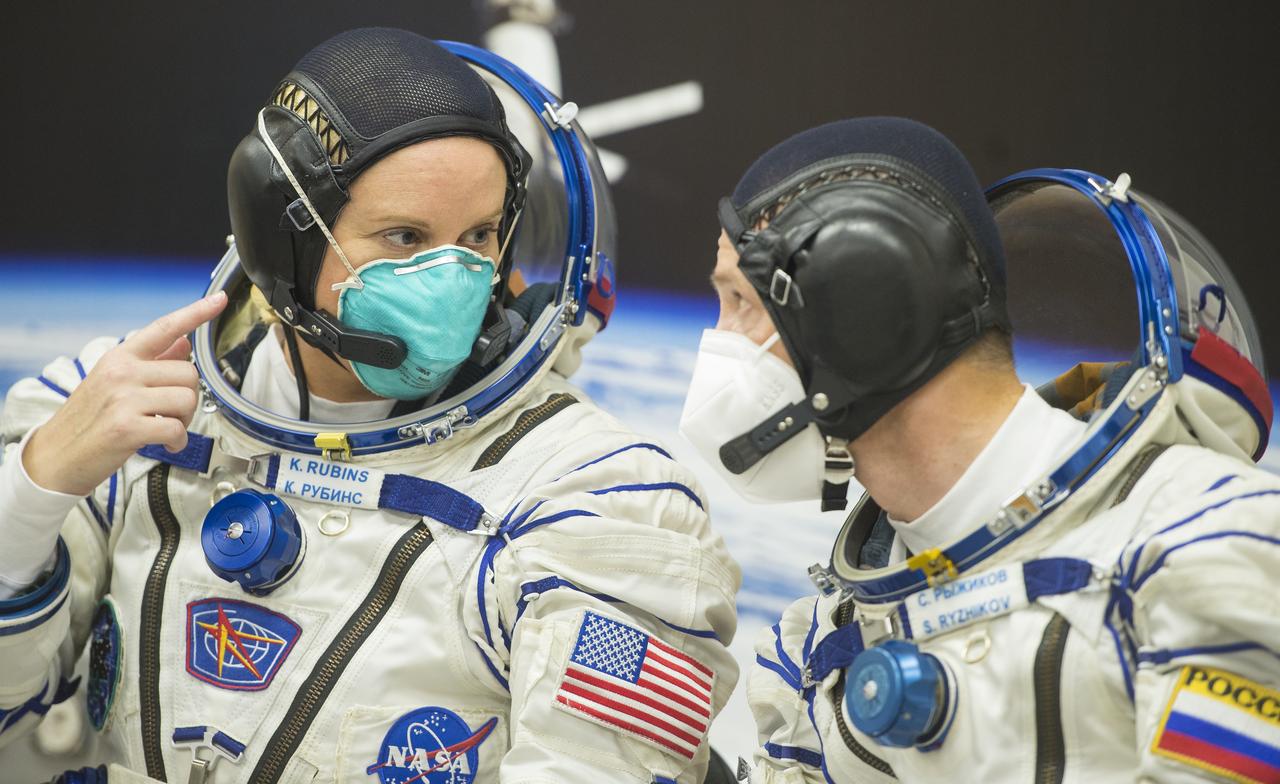 Expedition 64 NASA astronaut Kate Rubins, left, and Russian cosmonaut Sergey Ryzhikov, left, are seen following Russian Sokol suit pressure checks as they and fellow crewmate Sergey Kud-Sverchkov of Roscosmos prepare for their Soyuz launch to the International Space Station Wednesday, Oct. 14, 2020, at the Baikonur Cosmodrome in Kazakhstan. The trio launched at 1:45 a.m. EDT to begin a six-month mission aboard the International Space Station. Photo Credit: (NASA/GCTC/Andrey Shelepin)