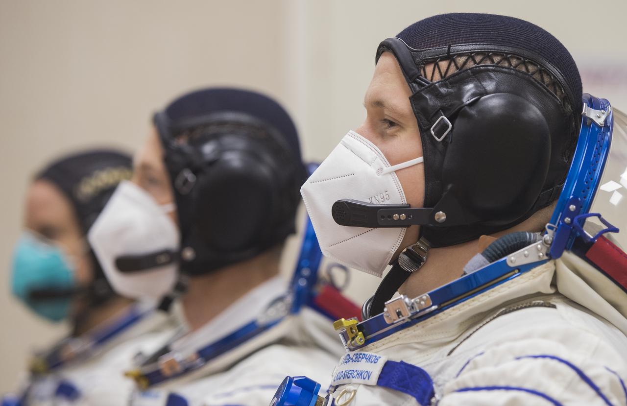 Expedition 64 Russian cosmonaut Sergey Kud-Sverchkov of Roscosmos, right, is seen with fellow crewmates Sergey Ryzhikov of Roscosmos and Kate Rubins of NASA as they speak with Roscosmos and NASA managers after having their Russian Sokol suits pressure checked, Wednesday, Oct. 14, 2020, at the Baikonur Cosmodrome in Kazakhstan. The trio launched at 1:45 a.m. EDT to begin a six-month mission aboard the International Space Station. Photo Credit: (NASA/GCTC/Andrey Shelepin)