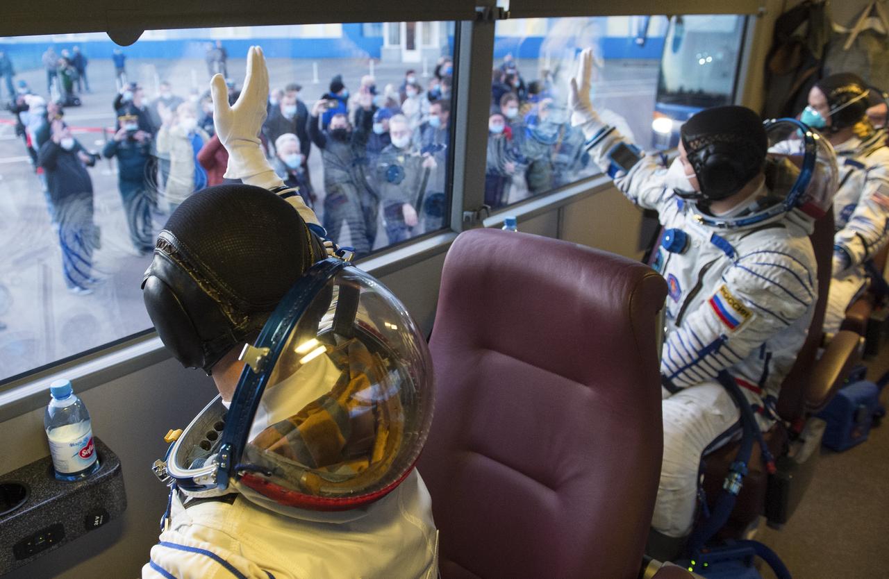 Expedition 64 Russian cosmonauts Sergey Ryzhikov, left, and Sergey Kud-Sverchkov, center, of Roscosmos and NASA astronaut Kate Rubins, right, wave as they depart Building 254 to head to their launch onboard the Soyuz MS-17 spacecraft, Wednesday, Oct. 14, 2020, at the Baikonur Cosmodrome in Kazakhstan.  The trio launched at 1:45 a.m. EDT to begin a six-month mission aboard the International Space Station. Photo Credit: (NASA/GCTC/Andrey Shelepin)