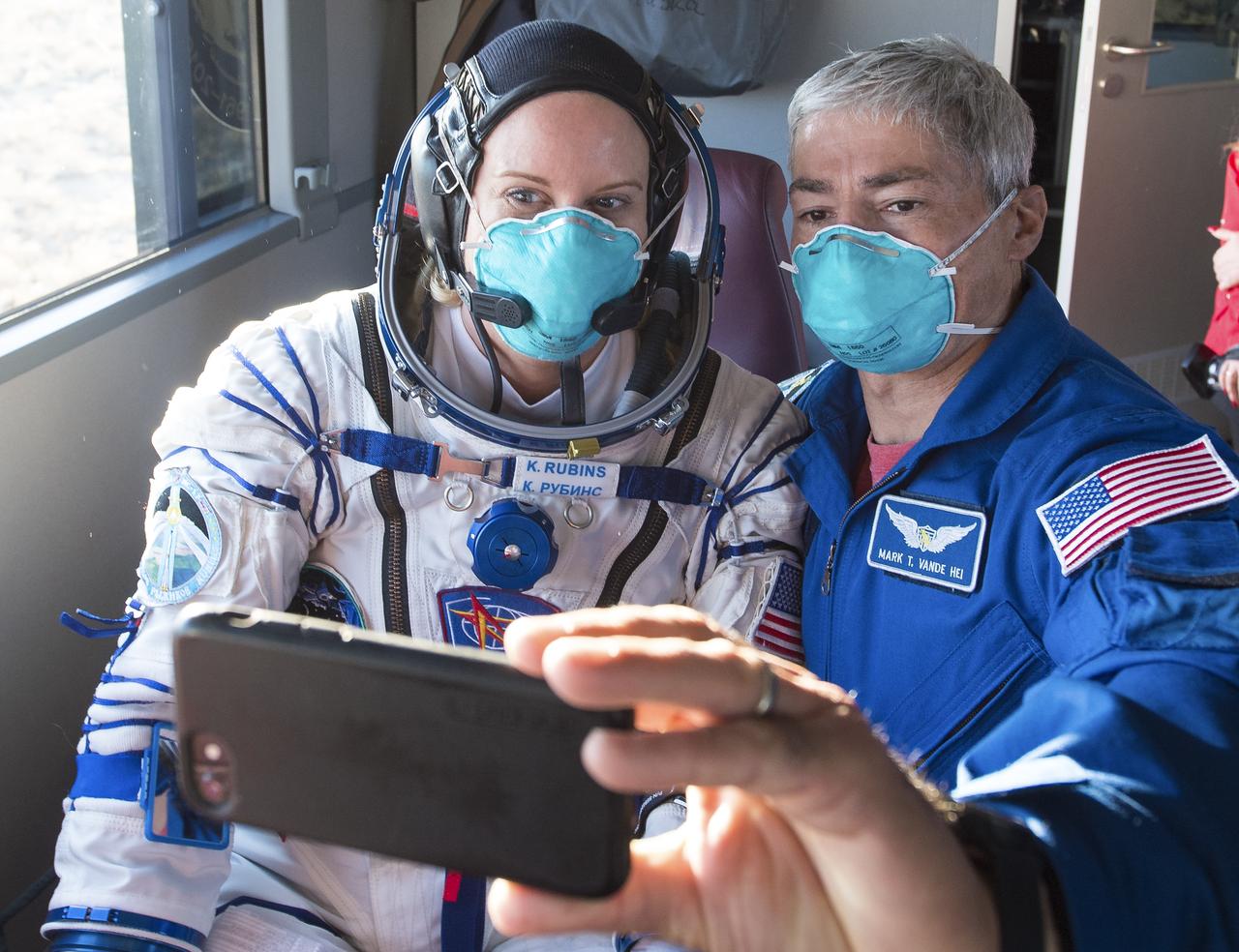 Expedition 64 NASA astronaut Kate Rubins and backup crew member NASA astronaut Mark Vande Hei take a selfie inside the bus carrying her and fellow crewmates Russian cosmonauts Sergey Kud-Sverchkov and Sergey Ryzhikov of Roscosmos to the launch pad, Wednesday, Oct. 14, 2020, at the Baikonur Cosmodrome in Kazakhstan. The trio launched at 1:45 a.m. EDT to begin a six-month mission aboard the International Space Station. Photo Credit: (NASA/GCTC/Andrey Shelepin)