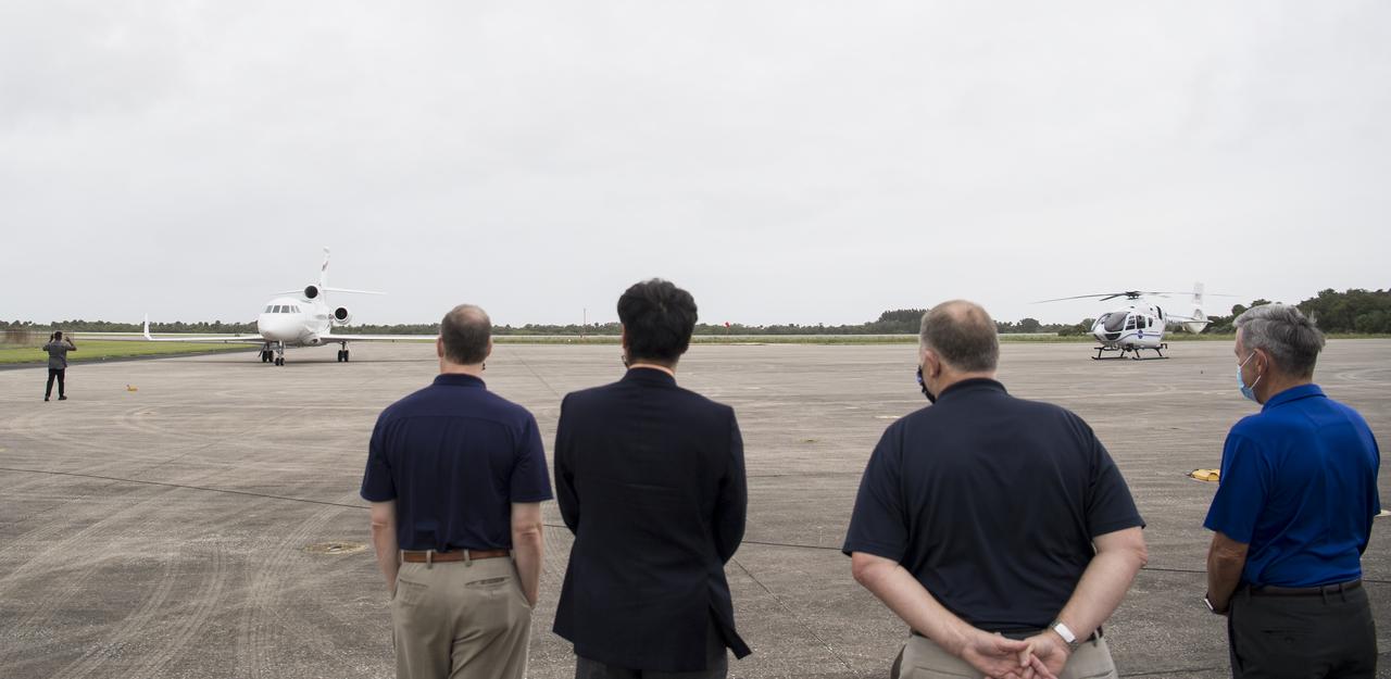 NASA Administrator Jim Bridenstine, left, Junichi Sakai, manager of the International Space Station Program for the Japan Aerospace Exploration Agency (JAXA), second from left, NASA Deputy Administrator Jim Morhard, second from right, and Kennedy Space Center Director Bob Cabana, right, watch as the plane carrying NASA astronauts Mike Hopkins, Victor Glover, and Shannon Walker, and astronaut Soichi Noguchi of the Japan Aerospace Exploration Agency (JAXA) arrives at the Launch and Landing Facility at NASA’s Kennedy Space Center ahead of SpaceX’s Crew-1 mission, Sunday, Nov. 8, 2020, in Florida. NASA’s SpaceX Crew-1 mission is the first operational mission of the SpaceX Crew Dragon spacecraft and Falcon 9 rocket to the International Space Station as part of the agency’s Commercial Crew Program. Hopkins, Glover, Walker, Noguchi are scheduled to launch at 7:49 p.m. EST on Saturday, Nov. 14, from Launch Complex 39A at the Kennedy Space Center. Photo Credit: (NASA/Joel Kowsky)