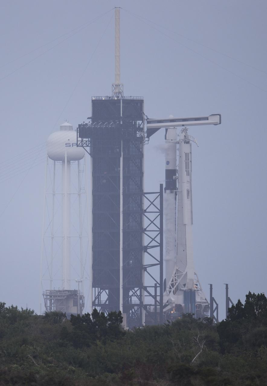 A SpaceX Falcon 9 rocket with the company's Crew Dragon spacecraft onboard is seen on the launch pad at Launch Complex 39A during a brief static fire test ahead of NASA’s SpaceX Crew-1 mission, Wednesday, Nov. 11, 2020, at NASA’s Kennedy Space Center in Florida. NASA’s SpaceX Crew-1 mission is the first operational mission of the SpaceX Crew Dragon spacecraft and Falcon 9 rocket to the International Space Station as part of the agency’s Commercial Crew Program. NASA astronauts Mike Hopkins, Victor Glover, and Shannon Walker, and astronaut Soichi Noguchi of the Japan Aerospace Exploration Agency (JAXA) are scheduled to launch at 7:49 p.m. EST on Saturday, Nov. 14, from Launch Complex 39A at the Kennedy Space Center. Photo Credit: (NASA/Joel Kowsky)